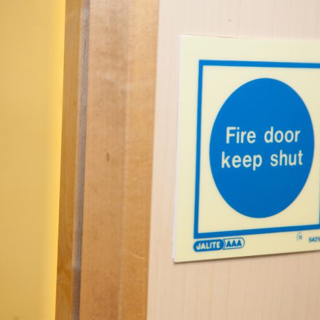 fire door keep shut sign on wall