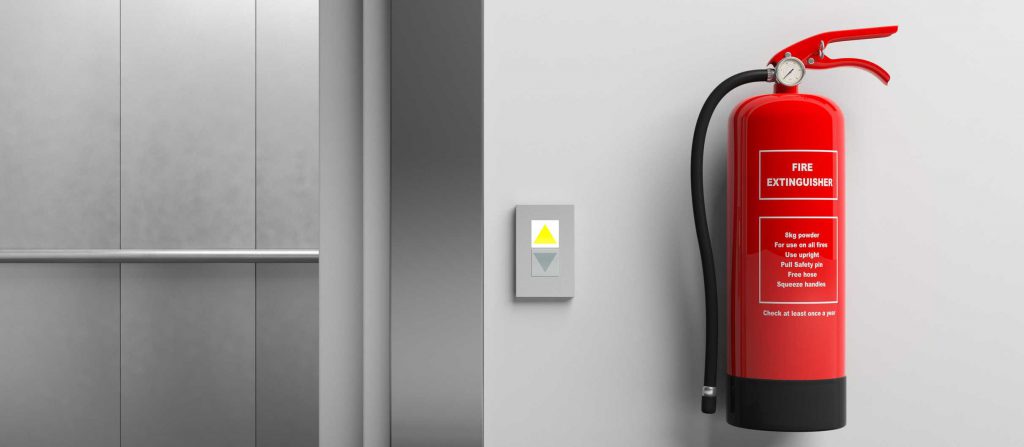 Red fire extinguisher on a wall and elevator with open doors
