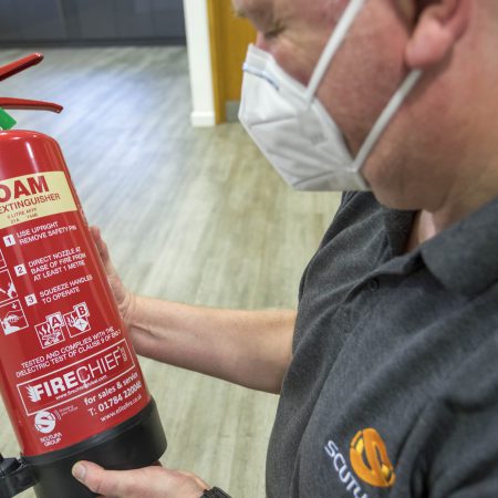 Team member at Scutum holding a foam fire extinguisher