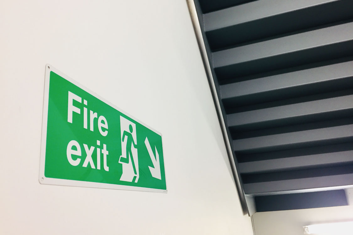 fire exit sign on the wall of a stairway 