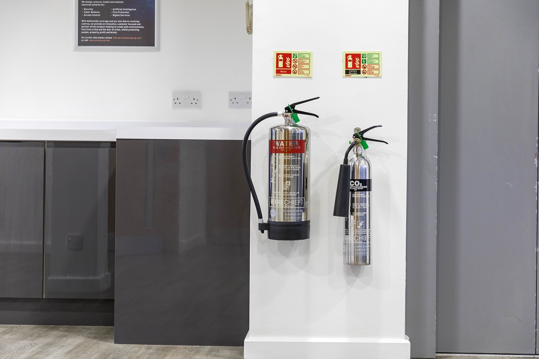 silver fire extinguishers on a wall