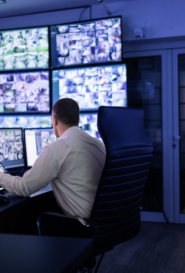 man in cctv control room conducting security system monitoring